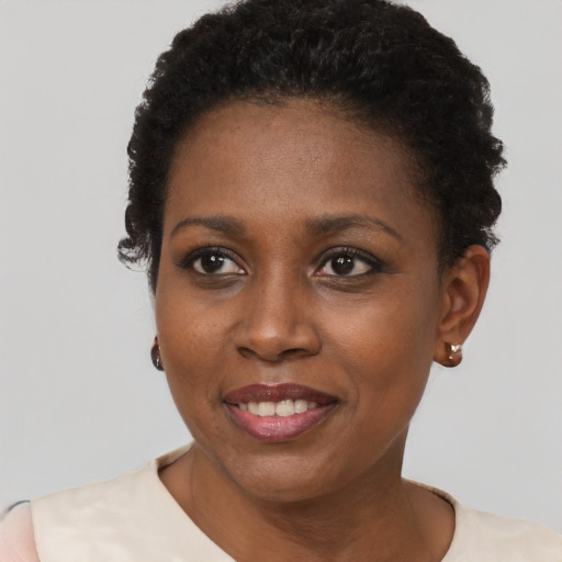 Joyful black young-adult female with short  black hair and brown eyes