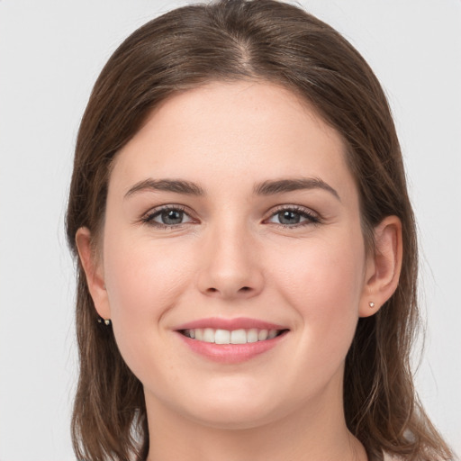 Joyful white young-adult female with long  brown hair and grey eyes