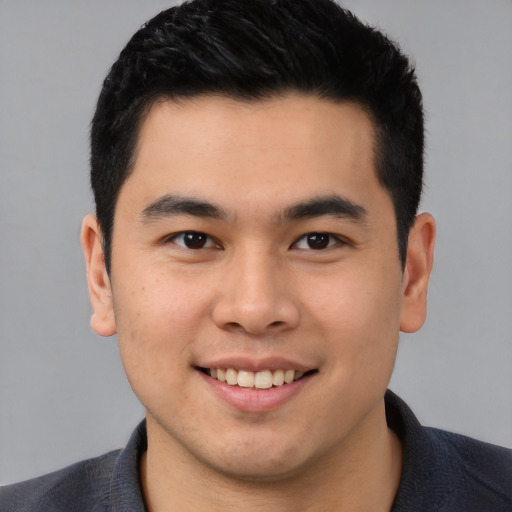 Joyful asian young-adult male with short  brown hair and brown eyes