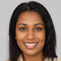 Joyful black young-adult female with long  brown hair and brown eyes