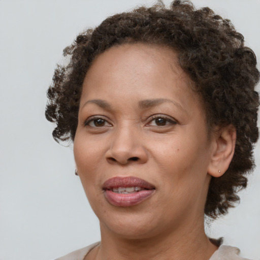 Joyful black adult female with medium  brown hair and brown eyes