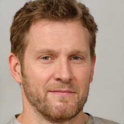 Joyful white adult male with short  brown hair and grey eyes