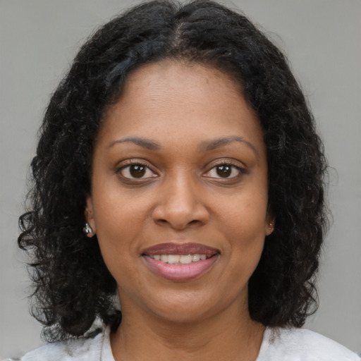 Joyful black young-adult female with medium  brown hair and brown eyes