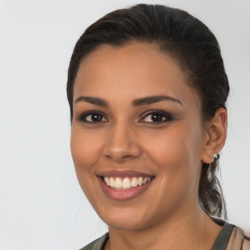 Joyful latino young-adult female with medium  brown hair and brown eyes