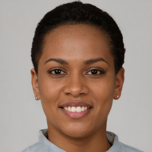 Joyful black young-adult female with short  black hair and brown eyes