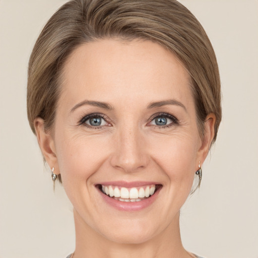 Joyful white young-adult female with medium  brown hair and green eyes