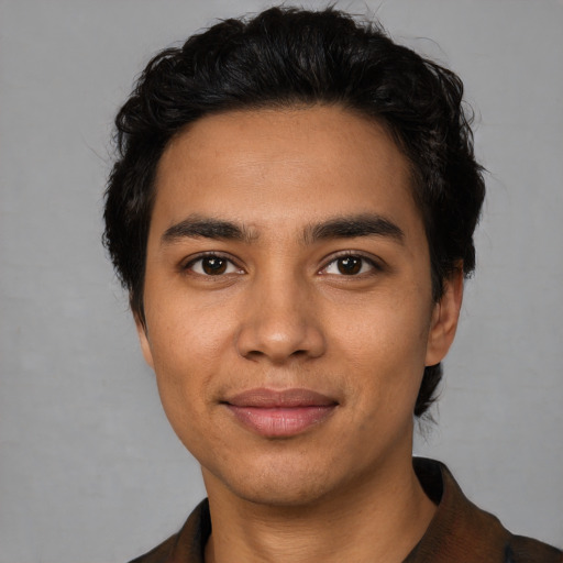 Joyful latino young-adult male with short  black hair and brown eyes