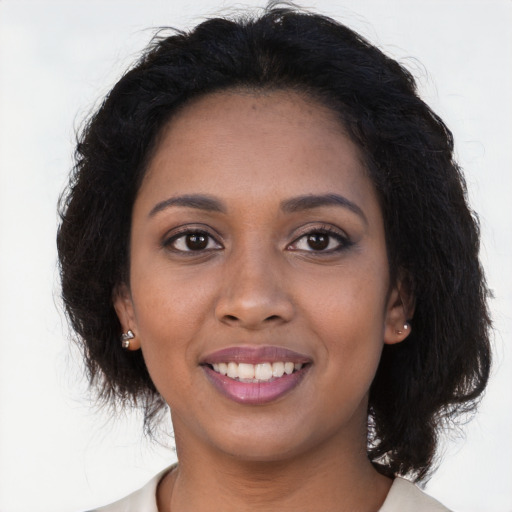 Joyful black young-adult female with long  brown hair and brown eyes