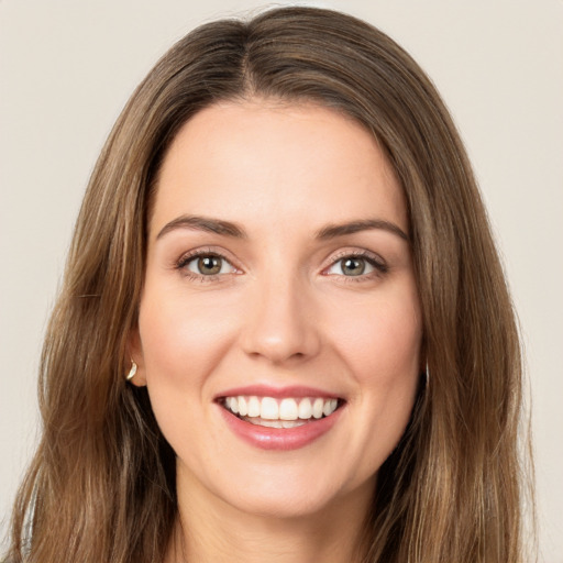 Joyful white young-adult female with long  brown hair and green eyes