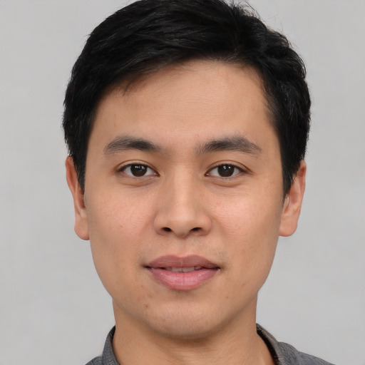 Joyful asian young-adult male with short  black hair and brown eyes