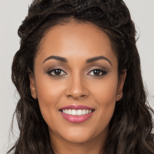 Joyful latino young-adult female with long  brown hair and brown eyes