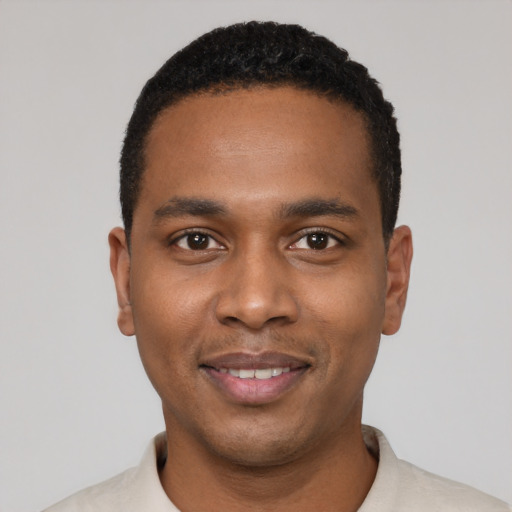 Joyful black young-adult male with short  black hair and brown eyes