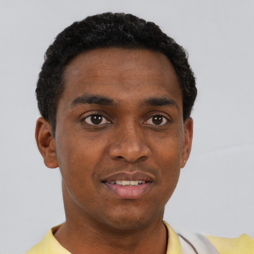 Joyful black young-adult male with short  brown hair and brown eyes