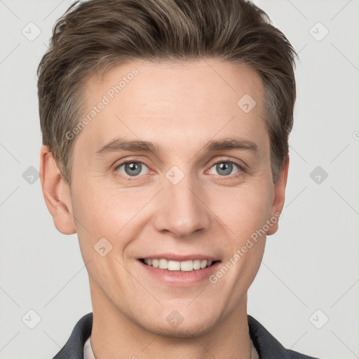 Joyful white young-adult male with short  brown hair and grey eyes