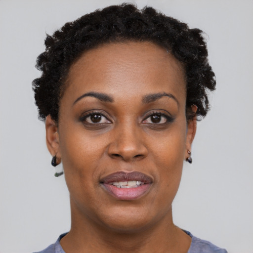 Joyful black adult female with short  black hair and brown eyes