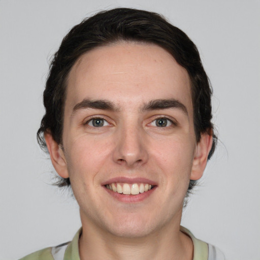 Joyful white young-adult male with medium  brown hair and green eyes