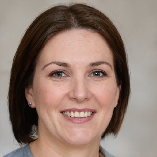 Joyful white adult female with medium  brown hair and grey eyes