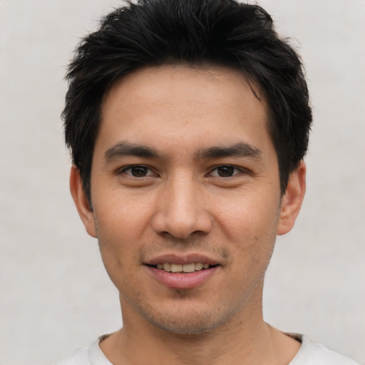 Joyful white young-adult male with short  black hair and brown eyes