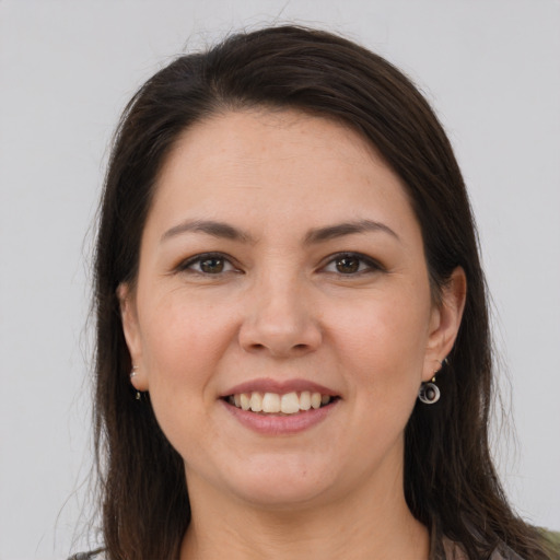 Joyful white young-adult female with long  brown hair and brown eyes