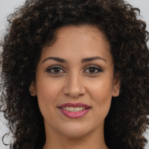 Joyful latino young-adult female with medium  brown hair and brown eyes