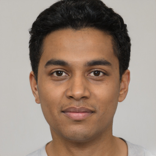 Joyful latino young-adult male with short  black hair and brown eyes