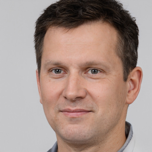 Joyful white adult male with short  brown hair and brown eyes