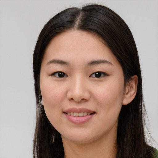 Joyful asian young-adult female with long  brown hair and brown eyes
