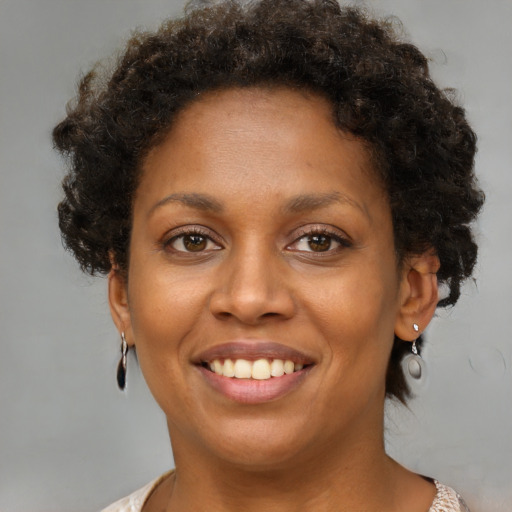 Joyful black young-adult female with short  brown hair and brown eyes