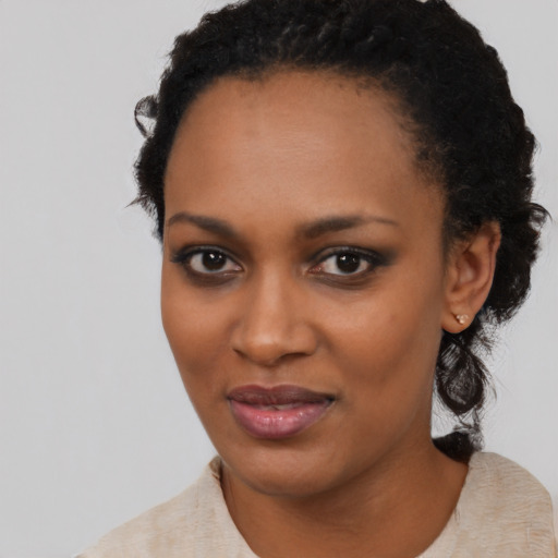 Joyful black young-adult female with short  black hair and brown eyes