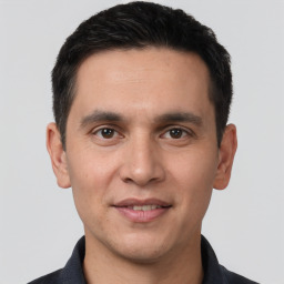 Joyful white young-adult male with short  black hair and brown eyes