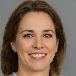 Joyful white adult female with medium  brown hair and grey eyes