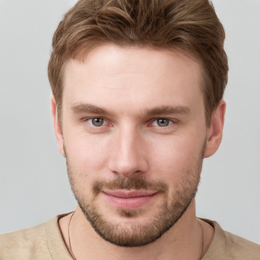 Joyful white young-adult male with short  brown hair and grey eyes