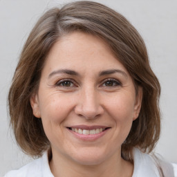 Joyful white adult female with medium  brown hair and grey eyes