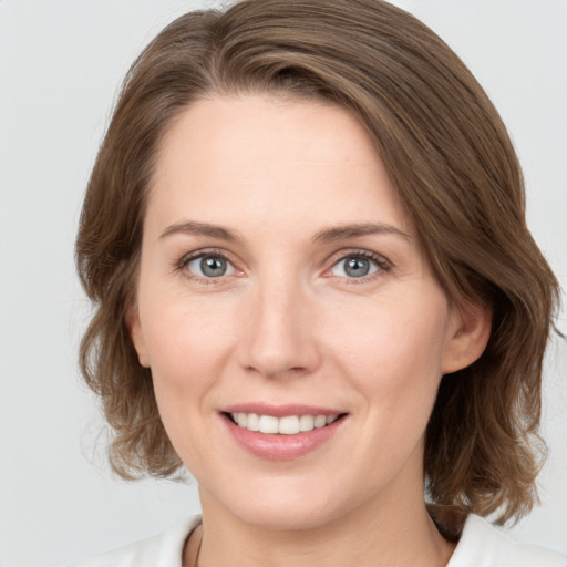 Joyful white young-adult female with medium  brown hair and green eyes