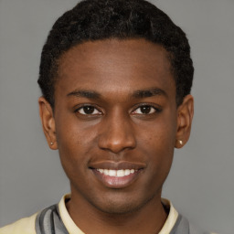 Joyful black young-adult male with short  brown hair and brown eyes