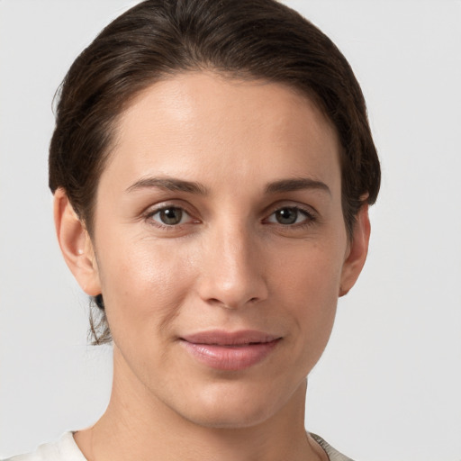 Joyful white young-adult female with short  brown hair and grey eyes