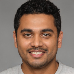 Joyful latino young-adult male with short  black hair and brown eyes