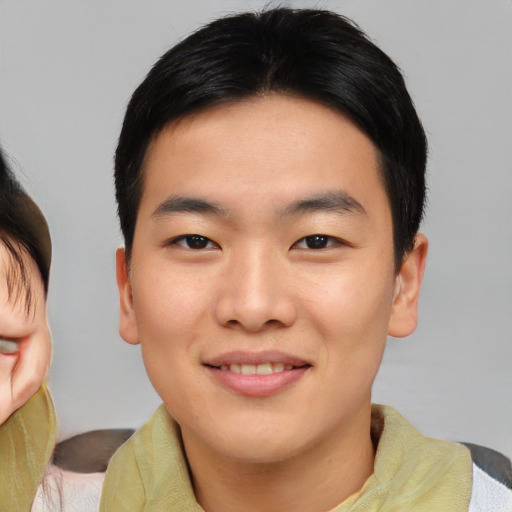 Joyful asian young-adult male with short  brown hair and brown eyes