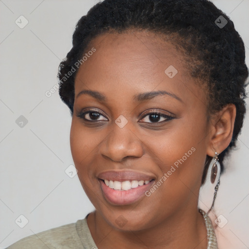 Joyful black young-adult female with short  black hair and brown eyes