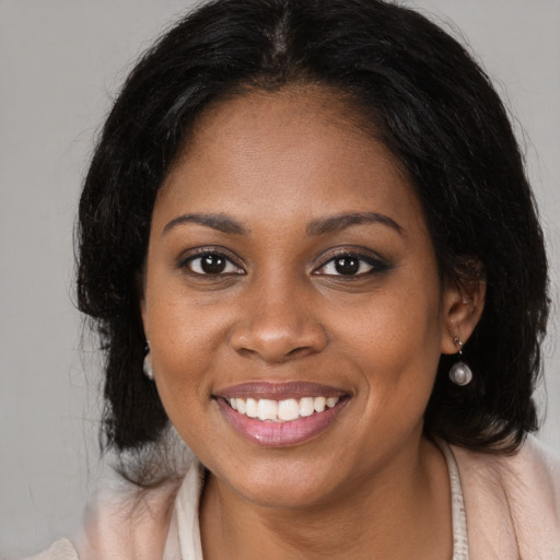 Joyful black young-adult female with medium  brown hair and brown eyes