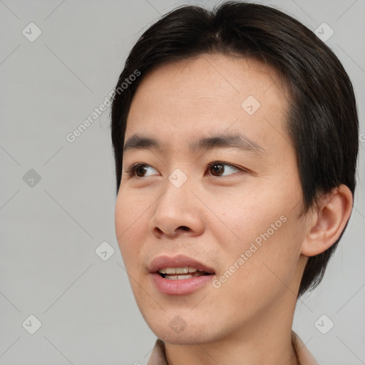 Joyful asian young-adult male with short  brown hair and brown eyes