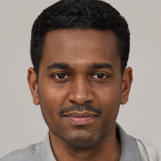 Joyful black young-adult male with short  black hair and brown eyes