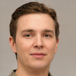 Joyful white young-adult male with short  brown hair and grey eyes