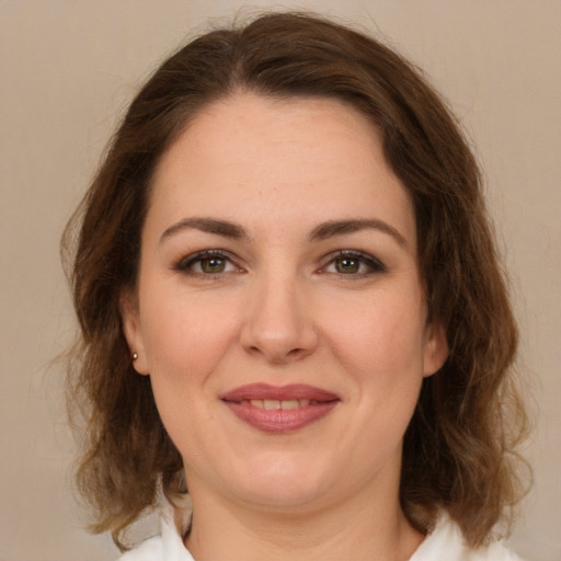 Joyful white young-adult female with medium  brown hair and green eyes