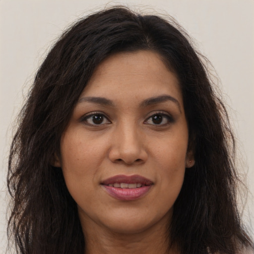 Joyful latino young-adult female with long  brown hair and brown eyes