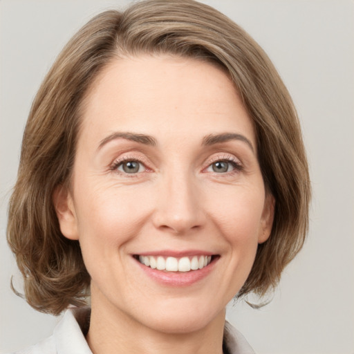 Joyful white young-adult female with medium  brown hair and green eyes