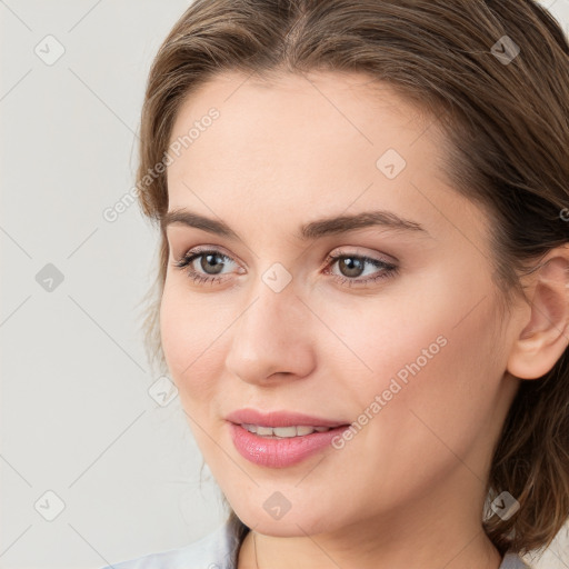 Joyful white young-adult female with medium  brown hair and blue eyes