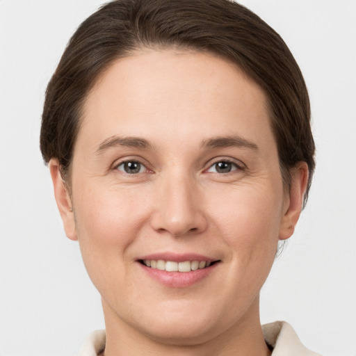 Joyful white young-adult female with short  brown hair and grey eyes