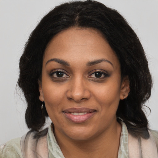 Joyful black young-adult female with long  brown hair and brown eyes