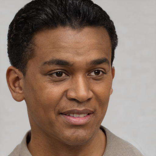Joyful latino young-adult male with short  brown hair and brown eyes